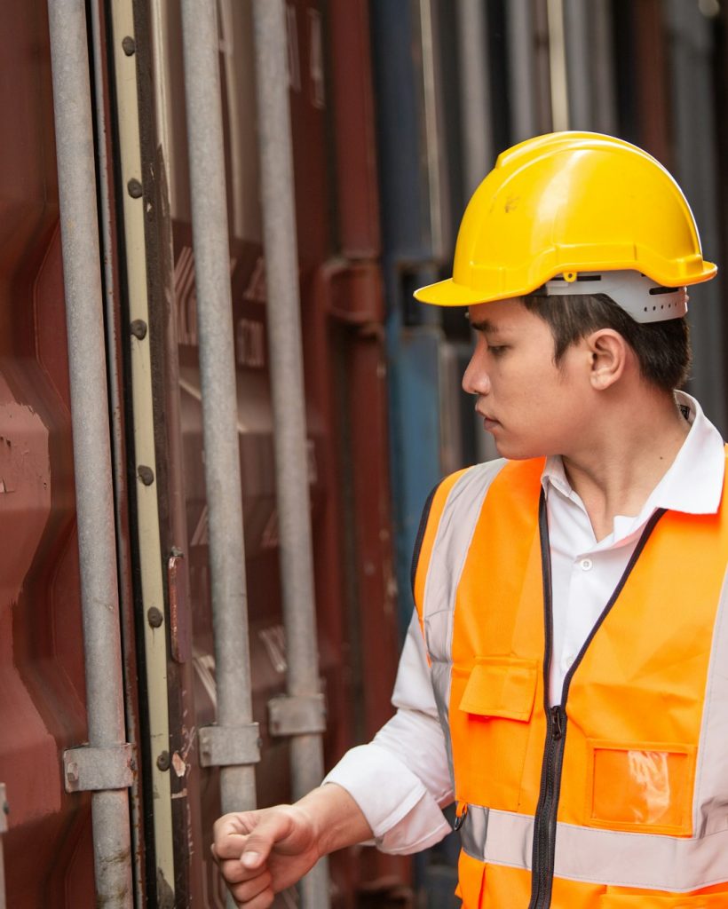 Logistic workers walking and checking stock shipping order at the container warehouse